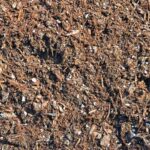 Close-up of Pro-Gro #9B Potting Soil Blend, a dark, coarse mix with woody fibers and small stones